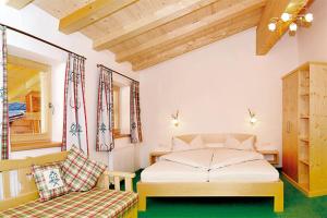 a bedroom with a bed and a chair and a window at Pension Biobauernhof Hinteraltensberg in Auffach