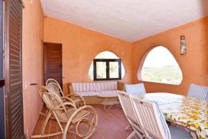 a room with a table and chairs and a couch at Villa Panoramica Vista Mare Costa Rei 3 Camere da letto in Monte Nai