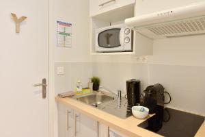 una pequeña cocina con fregadero y microondas en Nice Flat Ramblas Centre Toulouse, en Toulouse