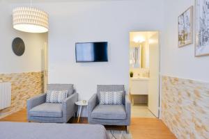1 dormitorio con 2 sillas y TV en la pared en Nice Flat Ramblas Centre Toulouse, en Toulouse