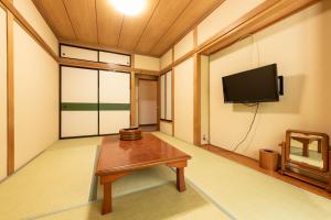 Habitación con mesa y TV de pantalla plana. en Yamanaka Lake Ryozan, en Yamanakako