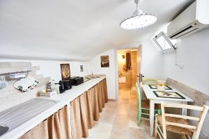a kitchen with a counter and a table with chairs at EQUORUM 13 - Ostuni Centro in Ostuni