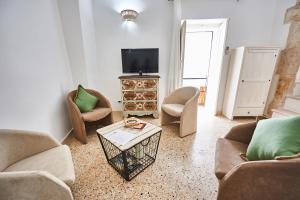 a living room with chairs and a tv and a table at EQUORUM 13 - Ostuni Centro in Ostuni