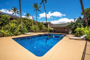 una piscina con palmeras y una casa en Kalama Terrace P309 en Kihei