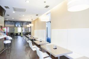 un restaurante con mesas blancas y sillas blancas en Hotel Valencia en Ferrol