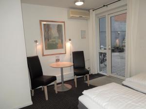 a room with a table and two chairs and a bed at Hotel Aarhus City Apartments in Aarhus