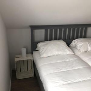 ビューズマー・ダイヒハウゼンにあるDeich-Husのベッドルーム1室(白いシーツ付きのベッド2台、ナイトスタンド付)