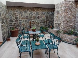a patio with a table and chairs and a stone wall at Hotel Molino in Ronda
