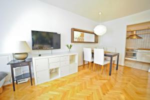 a living room with a dining table and a television at Grand Apartments Tulipan in Sopot