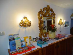 a table with books and a mirror on a wall at Pension Rainhof in Kitzbühel