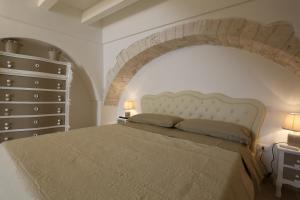 a bedroom with a large bed with an arch above it at CASA VACANZE IL RIFUGIO DEL PRINCIPE 2 in Putignano