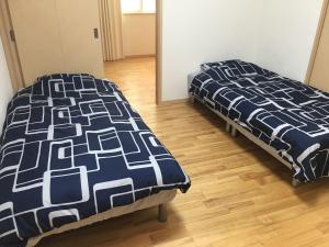 two beds sitting next to each other in a room at Katsuragawa House in Kami-tobachō