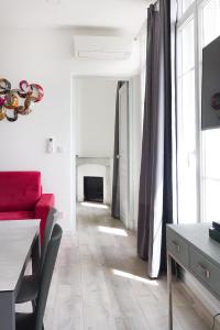 a living room with a red couch and a fireplace at Aux Iles d'Or in Hyères