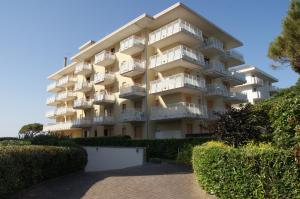 un gran edificio de apartamentos con balcones y arbustos en Appartamenti Diplomatic-Residence Fronte mare-Piazza Torino-Lido di Jesolo, en Lido di Jesolo