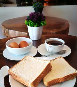 a table with toast and eggs and a cup of coffee at My Sj Hotel in Subang Jaya