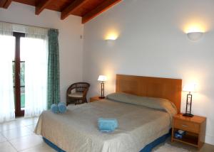 um quarto com uma cama com uma almofada azul em AlmaVerde Village & Spa Resort em Burgau