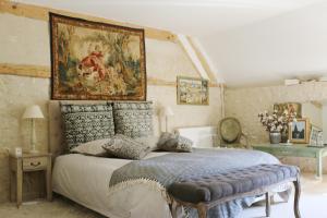 ein Schlafzimmer mit einem Bett und einem Wandgemälde in der Unterkunft Le bourgis in La Chapelle-Montligeon