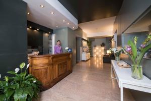 a man standing at the reception desk of a salon at Hotel Montestella in Salerno
