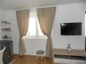 een woonkamer met een televisie en een raam bij House Marija in Brela