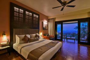 a bedroom with a large bed and a balcony at The Fern Samali Resort in Dapoli