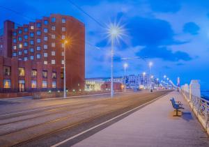 a bench on a street with buildings and street lights at Grand Hotel Blackpool in Blackpool