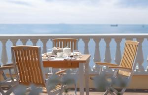 a table and chairs on a balcony with the ocean at GH Palazzo Suite & SPA in Livorno