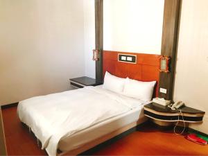 Una cama o camas en una habitación de Chang Ti Metropolis Commercial Hotel