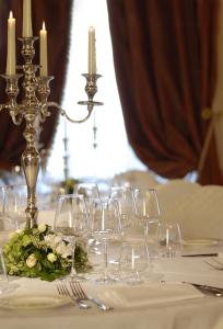 a table with wine glasses and acandle at GH Palazzo Suite & SPA in Livorno