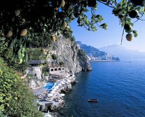 a large body of water next to a rocky cliff at Hotel Santa Caterina in Amalfi
