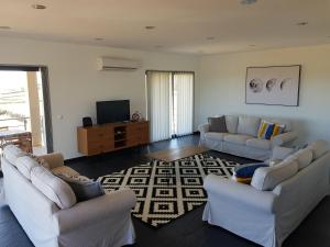a living room with two couches and a television at Casa Milhafre in Praia da Vitória