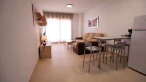 a kitchen and living room with a table and chairs at As Apartamentos Turisticos in El Morche