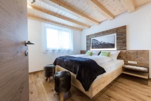 a bedroom with a large bed with a wooden headboard at Tallnerhof in Schenna