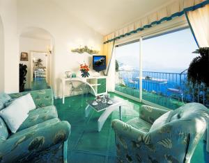 a living room with a couch and a table and a balcony at Hotel Santa Caterina in Amalfi