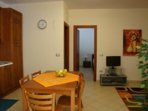 eine Küche und ein Esszimmer mit einem Tisch und einer Uhr in der Unterkunft Appartamenti Campo in Trappeto