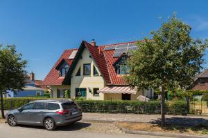 a car parked in front of a house with solar panels at Haus Arvert in Ostseebad Koserow