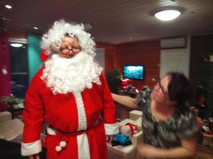 Eine Frau, die neben einem Mann steht, der in einem Santa-Kostüm gekleidet ist. in der Unterkunft Auroracabin Chalets in Saariselkä