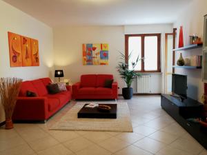 a living room with two red couches and a tv at Cagliari Family Apartment in Cagliari