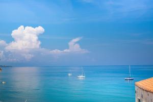 a group of boats floating in the ocean at Ossuna Bay Hotel Boutique in Cefalù