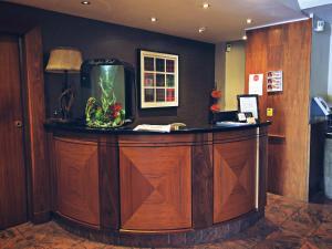 a lobby with a large wooden bar with an aquarium at Beaufort Hotel in Inverness