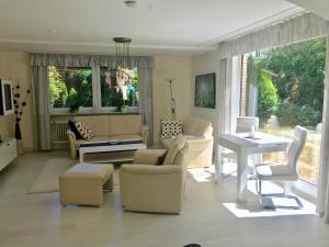 ein Wohnzimmer mit weißen Möbeln und einem großen Fenster in der Unterkunft FeWo im Grünen mit Terrasse und Garten - gratis Therme in Bad Bevensen