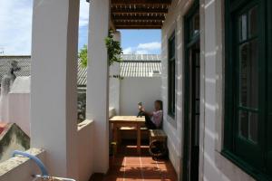 a man sitting at a table on the balcony of a house at Casa Sesimbra in Sesimbra