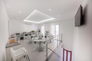 a white room with a table and chairs in it at Ossuna Bay Hotel Boutique in Cefalù