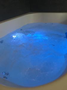 une baignoire remplie d'eau bleue sur une table dans l'établissement Les Mille et une Nuits, à Rouen