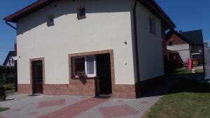 Casa blanca con ventana y puerta en Apartament Małgosia, en Swarzewo