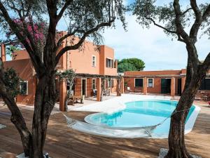 a hammock around a swimming pool in a courtyard with trees at Belvilla by OYO Villa Arangea Dieci in Marsala