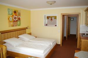 a bedroom with a bed and a kitchen with a sink at Pension Zur Alten Schmiede in Zwiesel