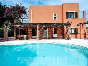 a swimming pool in front of a house at Belvilla by OYO Villa Arangea Dieci in Marsala