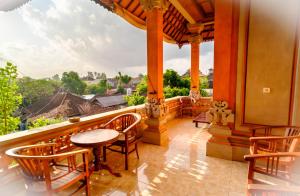 d'un balcon avec vue doté de chaises en bois et d'une table. dans l'établissement Bali Spring Cottages, à Ubud