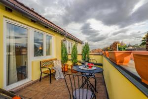 Elle comprend un petit balcon avec une table et des chaises. dans l'établissement Prague 1 SUNNY APT with terrace by Michal&Friends, à Prague