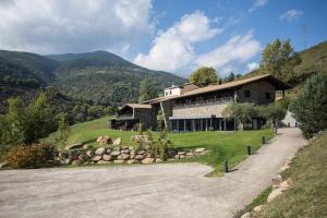 uma casa numa colina ao lado de uma estrada em Hotel Rural-Spa Resguard Dels Vents em Ribes de Freser